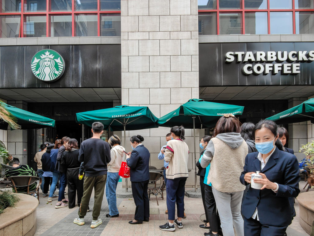 People line up outside a Starbucks outlet in Shanghai, China Tuesday, April 20, 2021.