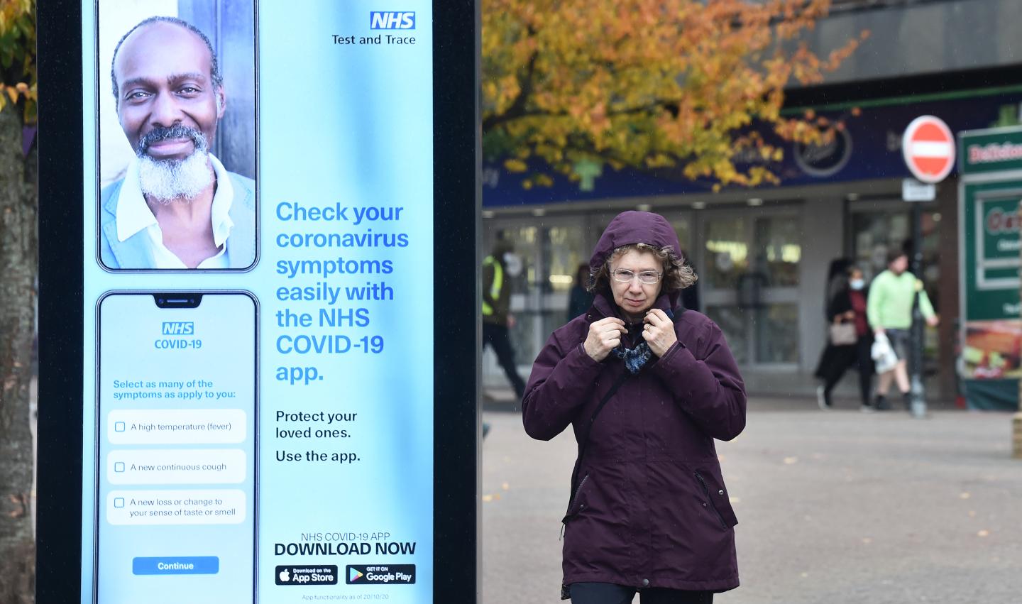 A women walks past an advert for the NHS Covid 19 App in Hanley as Staffordshire prepares to move into Tier 2 COVID-19 on October 28, 2020 in Stoke-on-Trent, Staffordshire.