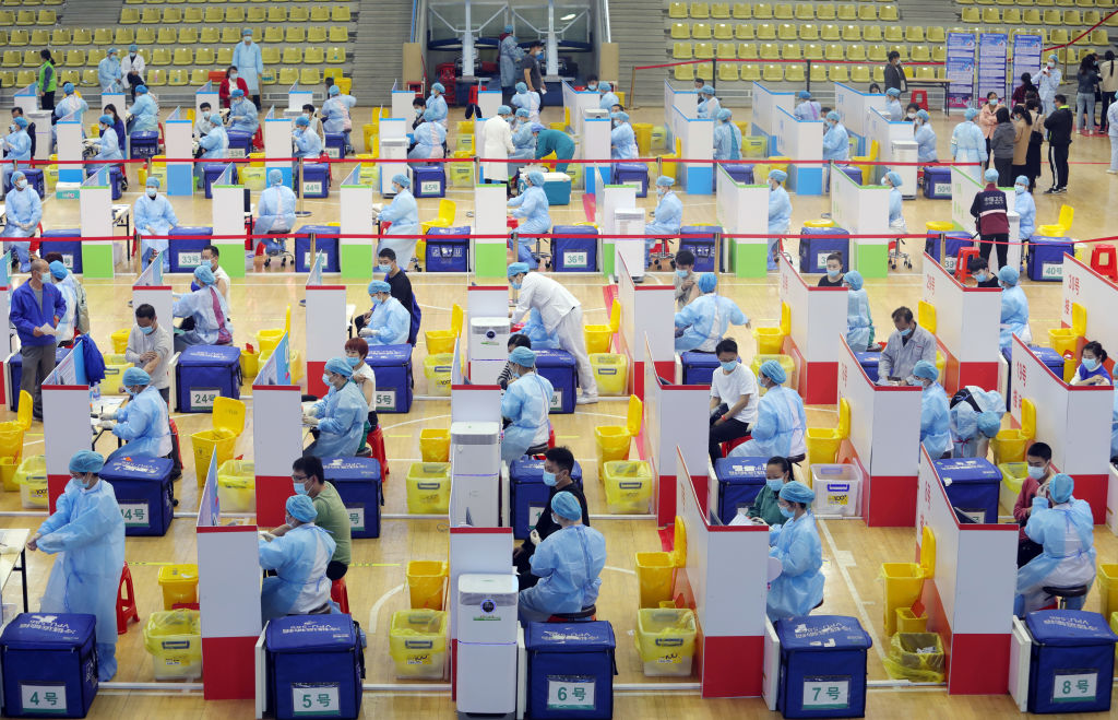Local residents line up to receive the COVID-19 vaccine at Tangsha gymnasium on March 23, 2021 in Dongguan, Guangdong Province of China.