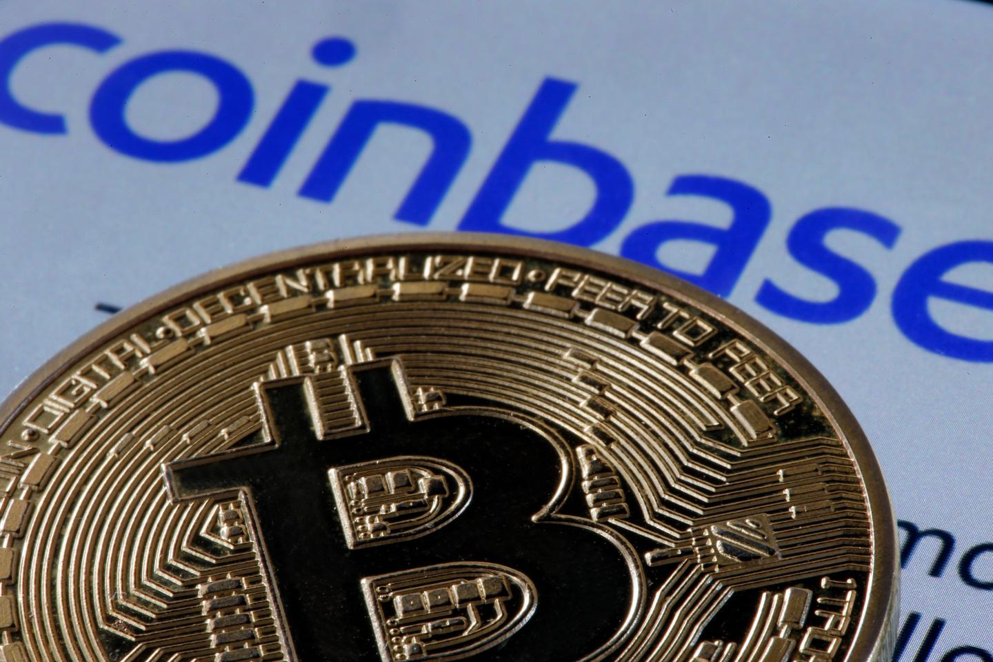 In this photo illustration, a visual representation of the digital Cryptocurrency, Bitcoin, is displayed in front of the home page of the Coinbase cryptocurrency exchange website on April 12, 2021 in Paris, France.