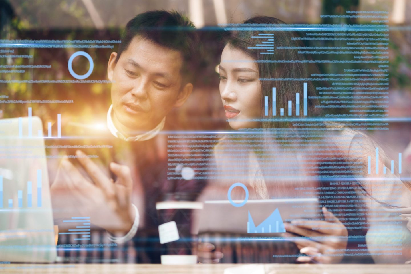 Man and woman work on screen while AI screen appear in front of them.