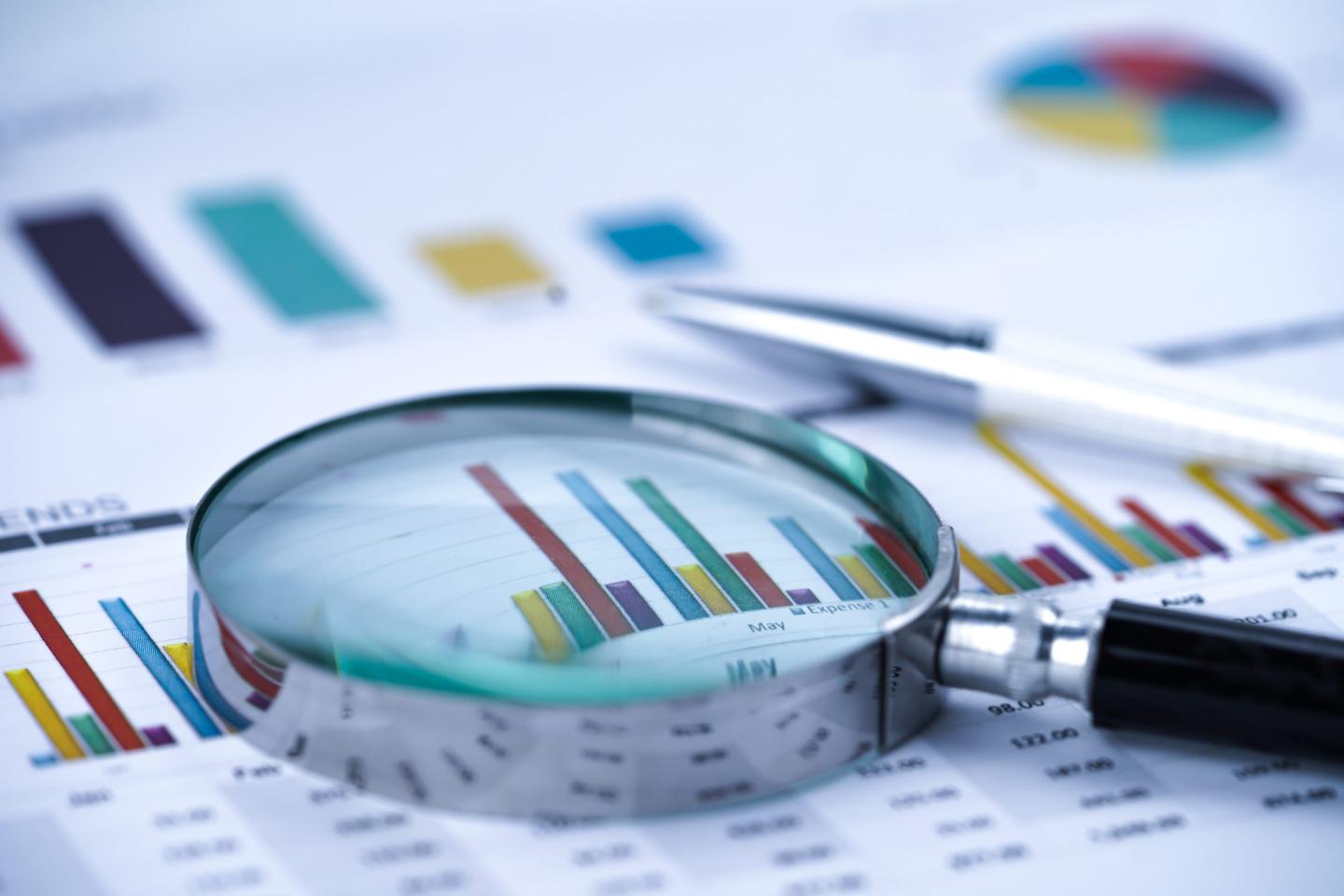 Magnifying glass on a paper chart of bars