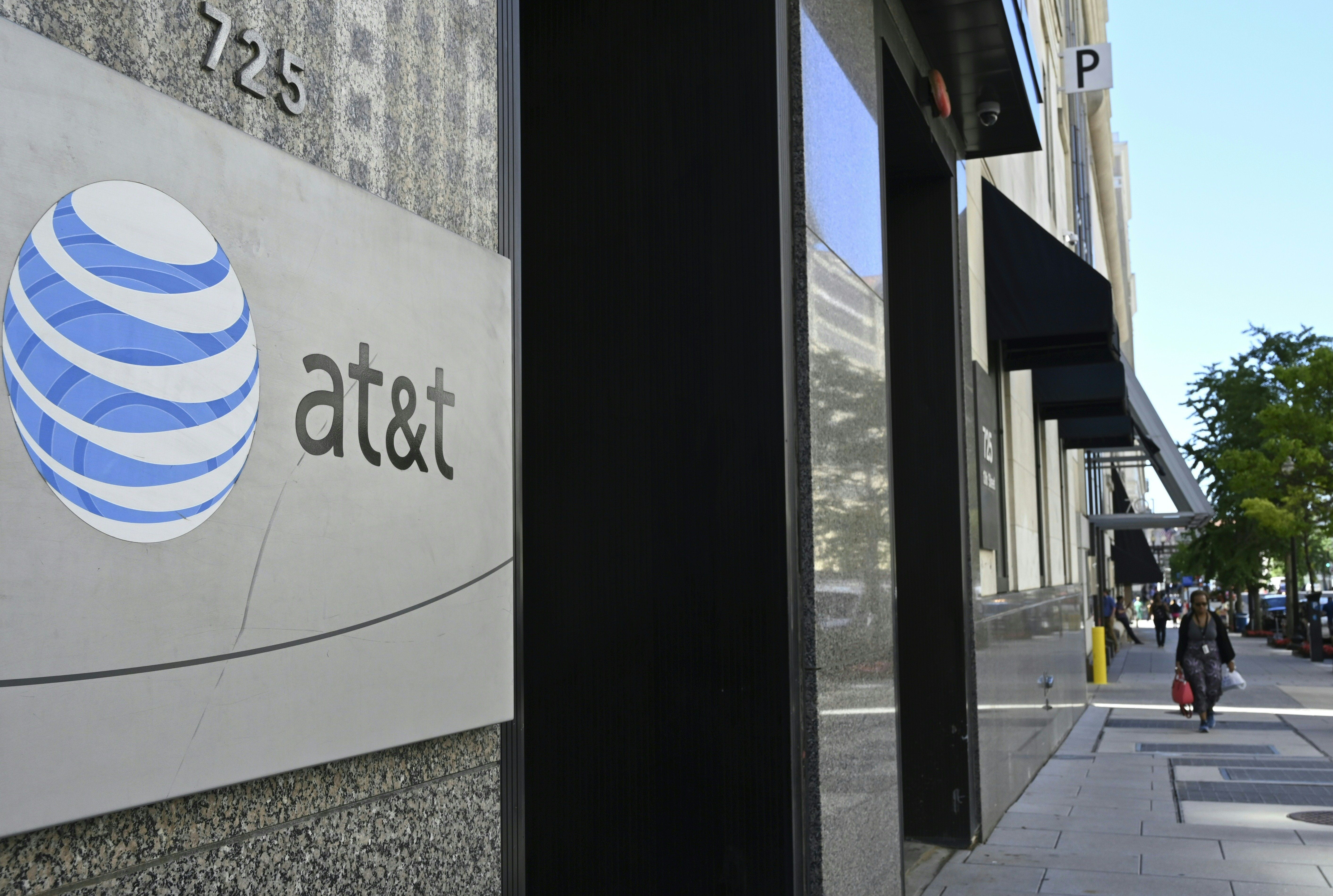An AT&;T telecommunication logo is seen at the entrance of a building in Washington, DC 