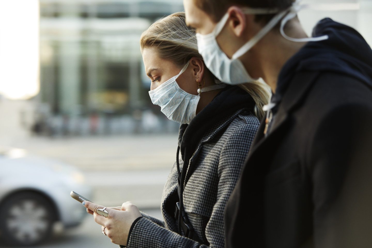 people in masks look at phone