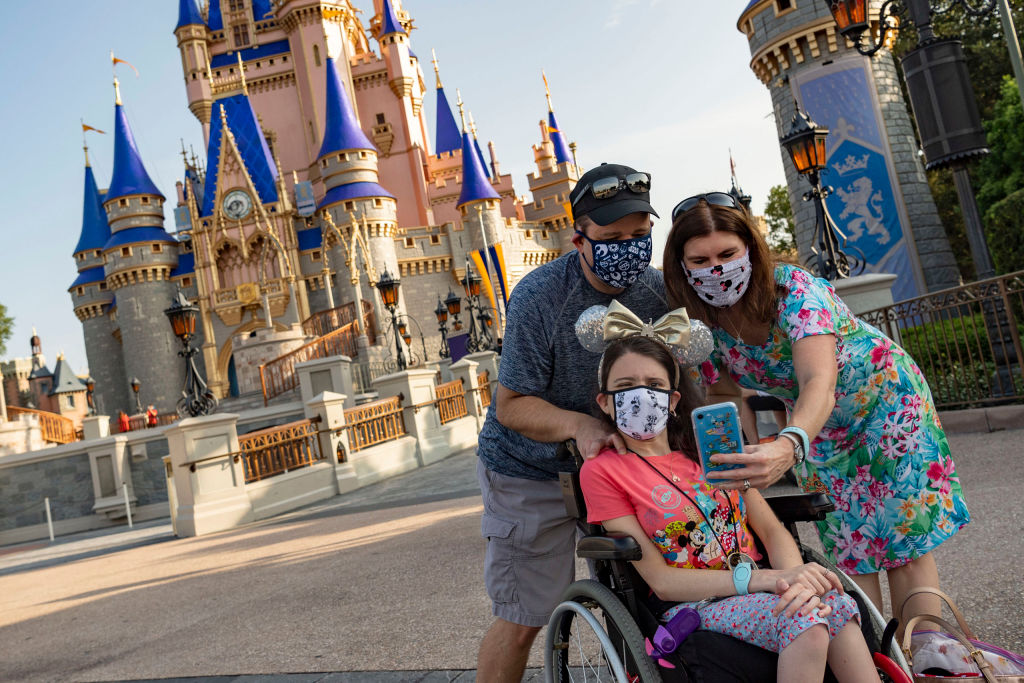 Guests take a selfie in the Magic Kingdom at Walt Disney World Resort on July 11, 2020, in Lake Buena Vista, Fla., the first day of the phased reopening.