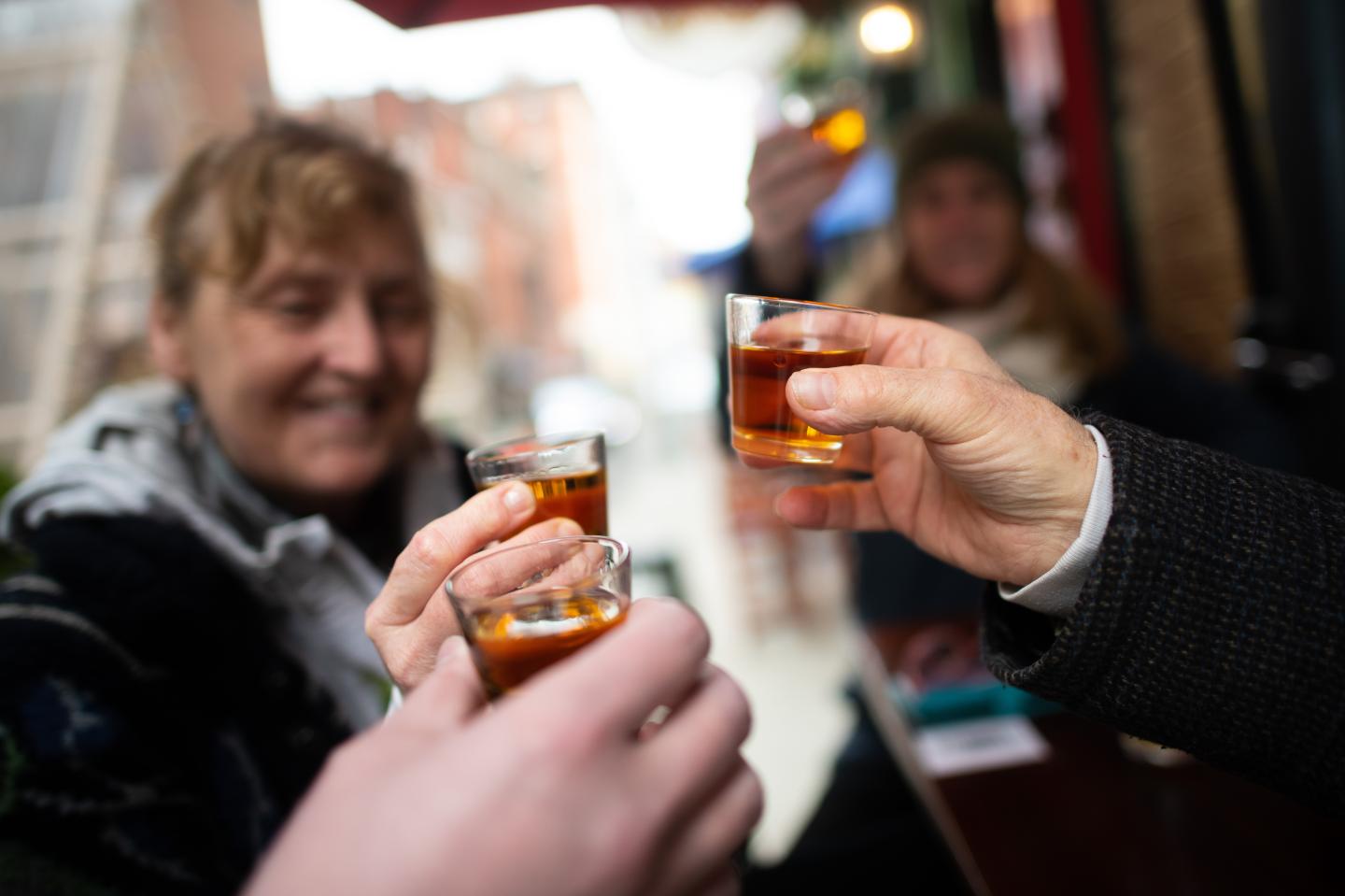 Friends toast before drinking a shot of whiskey on St. Patrick's Day at Fergie's Pub on March 17, 2021 in Philadelphia, Pennsylvania.