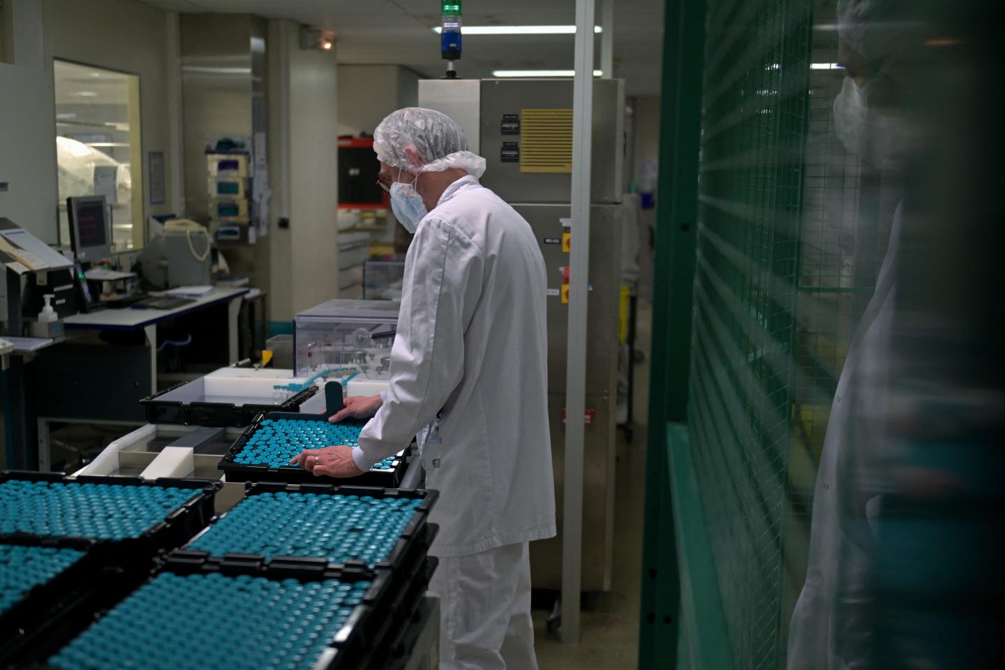 An employee checks bottles of diluent inside the pharmaceutical plant Fareva in Poce-sur-Cisse, Central France, on April 22, 2021. Fareva was chosen as the main supplier of the candidate RNA messenger vaccine from the German company CureVac. The site will therefore produce the diluent used in this vaccine.