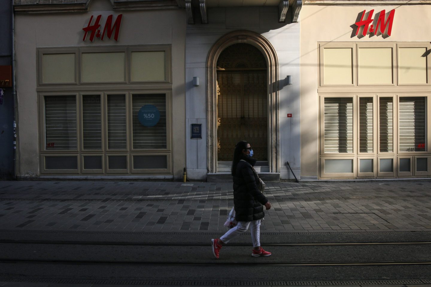 A woman walks past the closed H&M store on Istiklal Street,