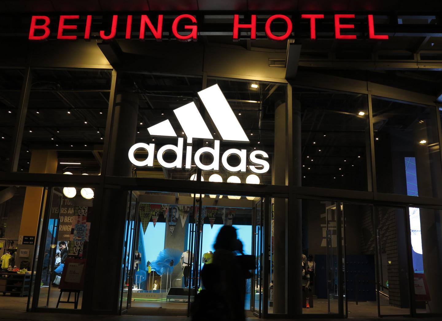 BEIJING, CHINA - APRIL 28, 2021 - Pedestrians pass in front of an Adidas store in the Wangfujing business district in Beijing, China, on April 28, 2021.