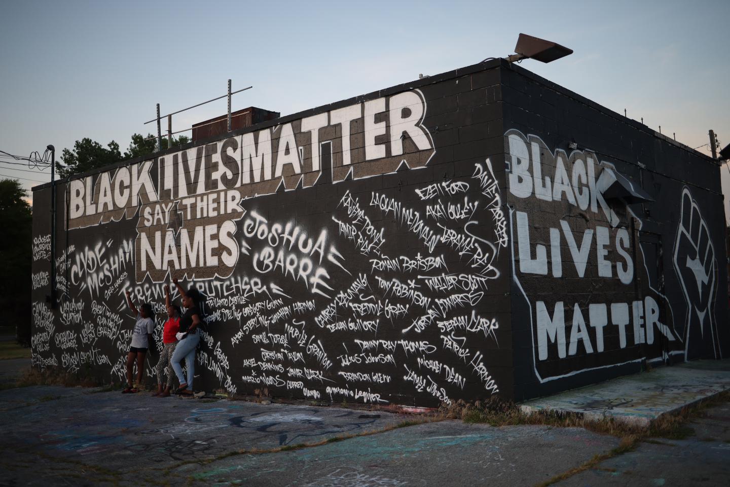 Children pose for photos in front of a mural painted on the side of Mad Dog Liquors June 18, 2020 in Tulsa, Oklahoma.