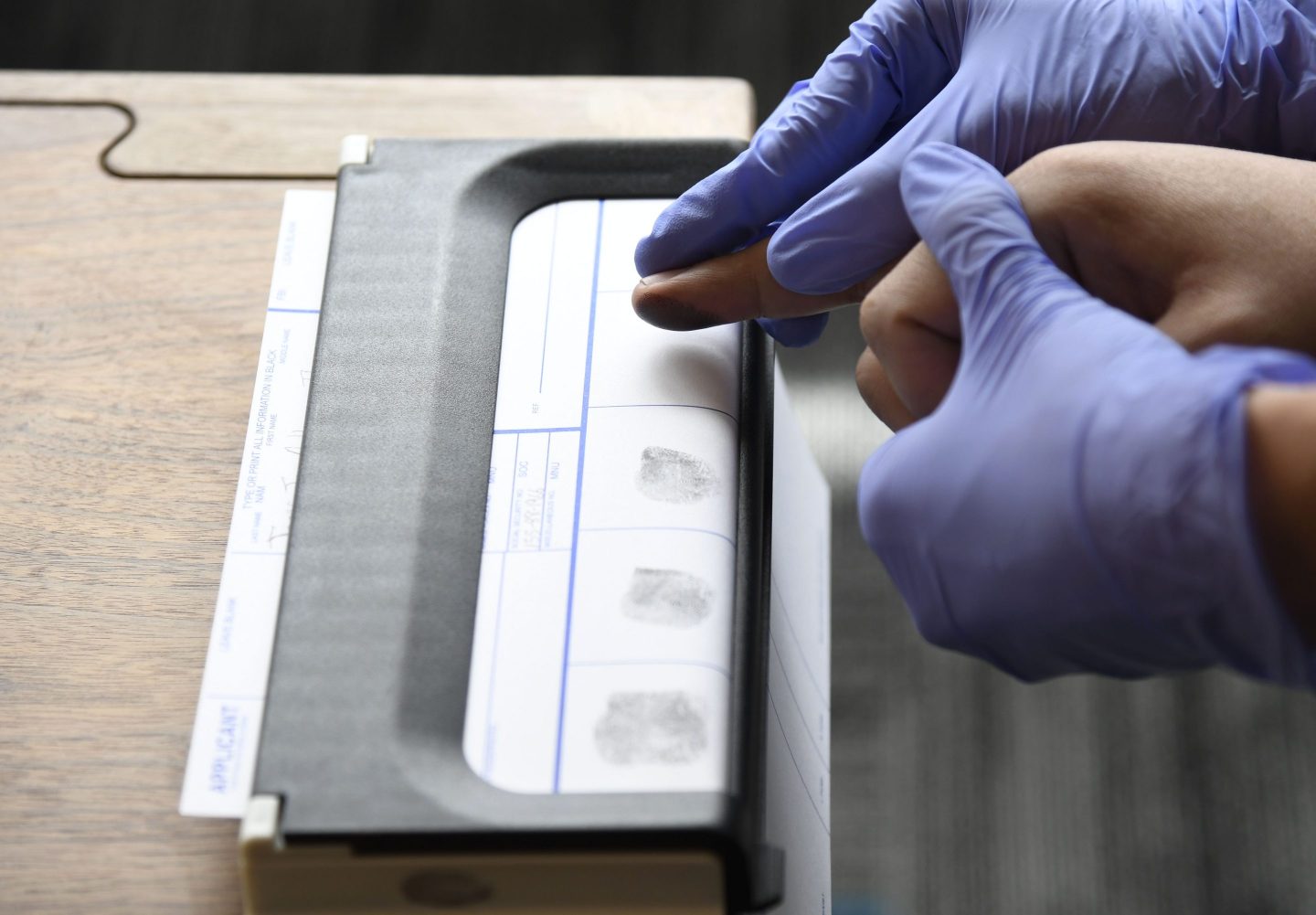 A HopSkipDrive driver undergoes fingerprinting during an orientation session in Denver. The ride-share startup “is unique in how it embeds trust into its operating model,” the authors write.