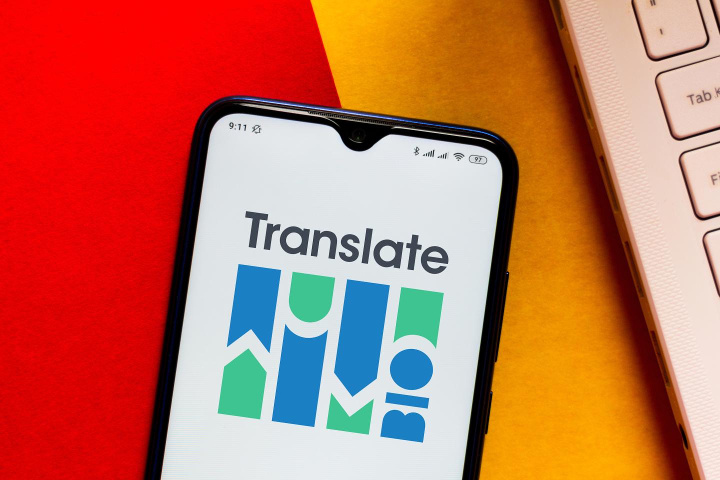 Translate Bio logo seen displayed on a smartphone sitting on a red and gold background