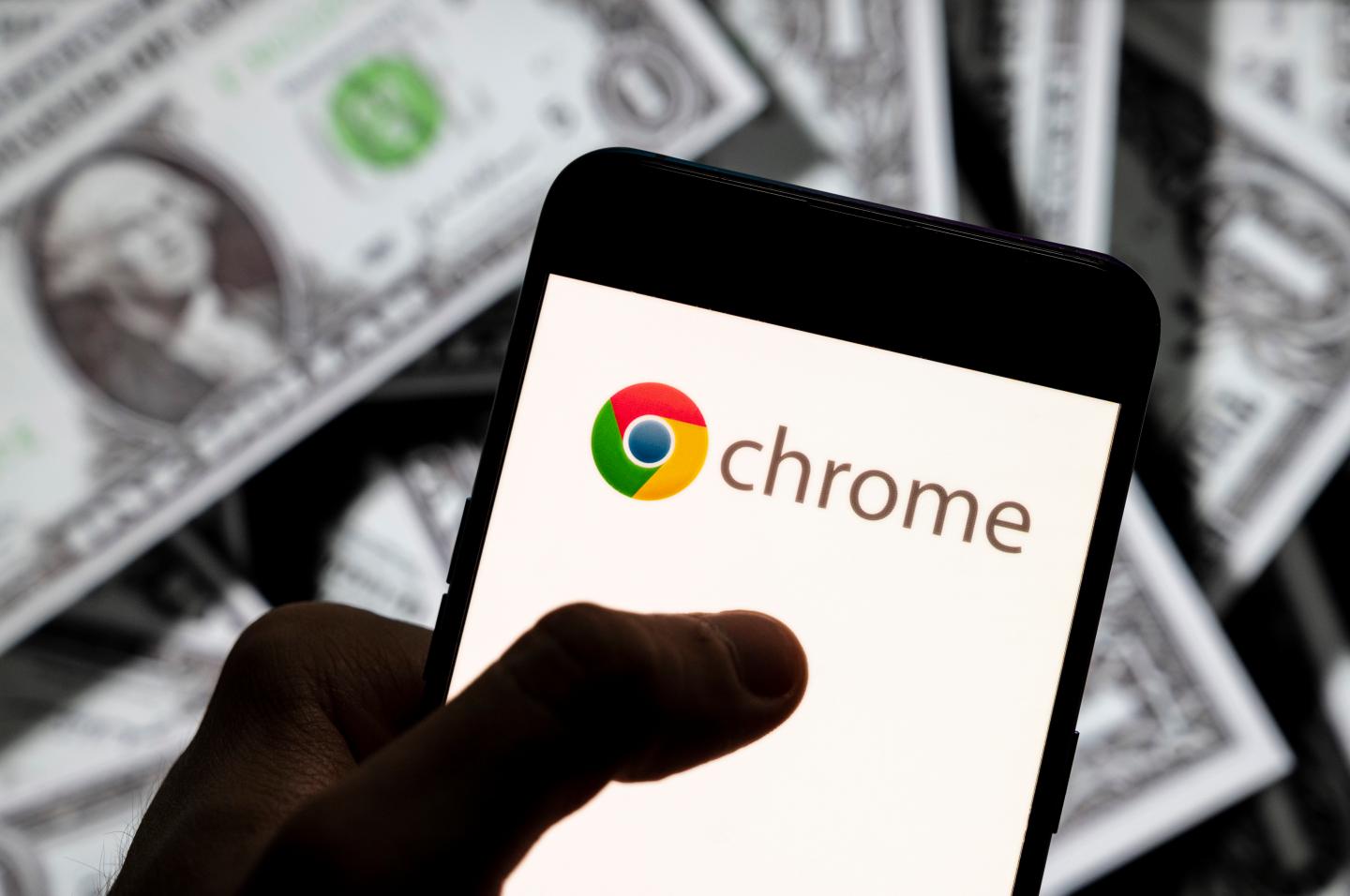In this photo illustration the American web browser developed by Google, Chrome logo seen displayed on a smartphone with USD (United States dollar) currency in the background.