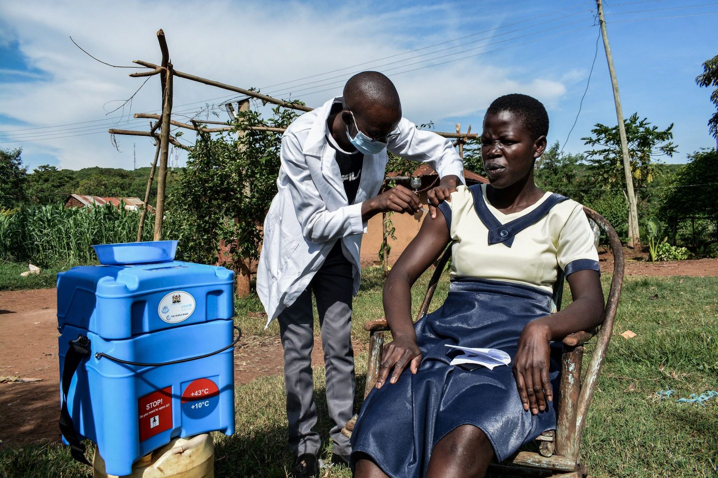 A medical health worker injects the Oxford/AstraZeneca Covid-19 vaccine to a woman as they visit door-to-door to deliver the vaccines to people who live far from health facilities in Siaya, Kenya
