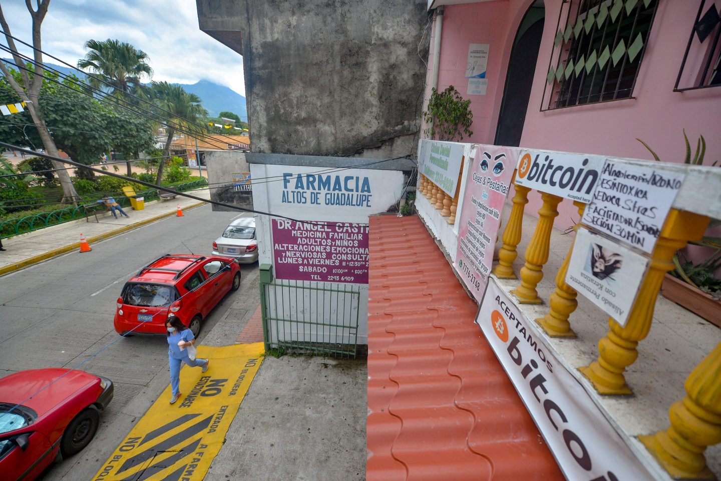 A woman passes by a local business that accepts bitcoin as a