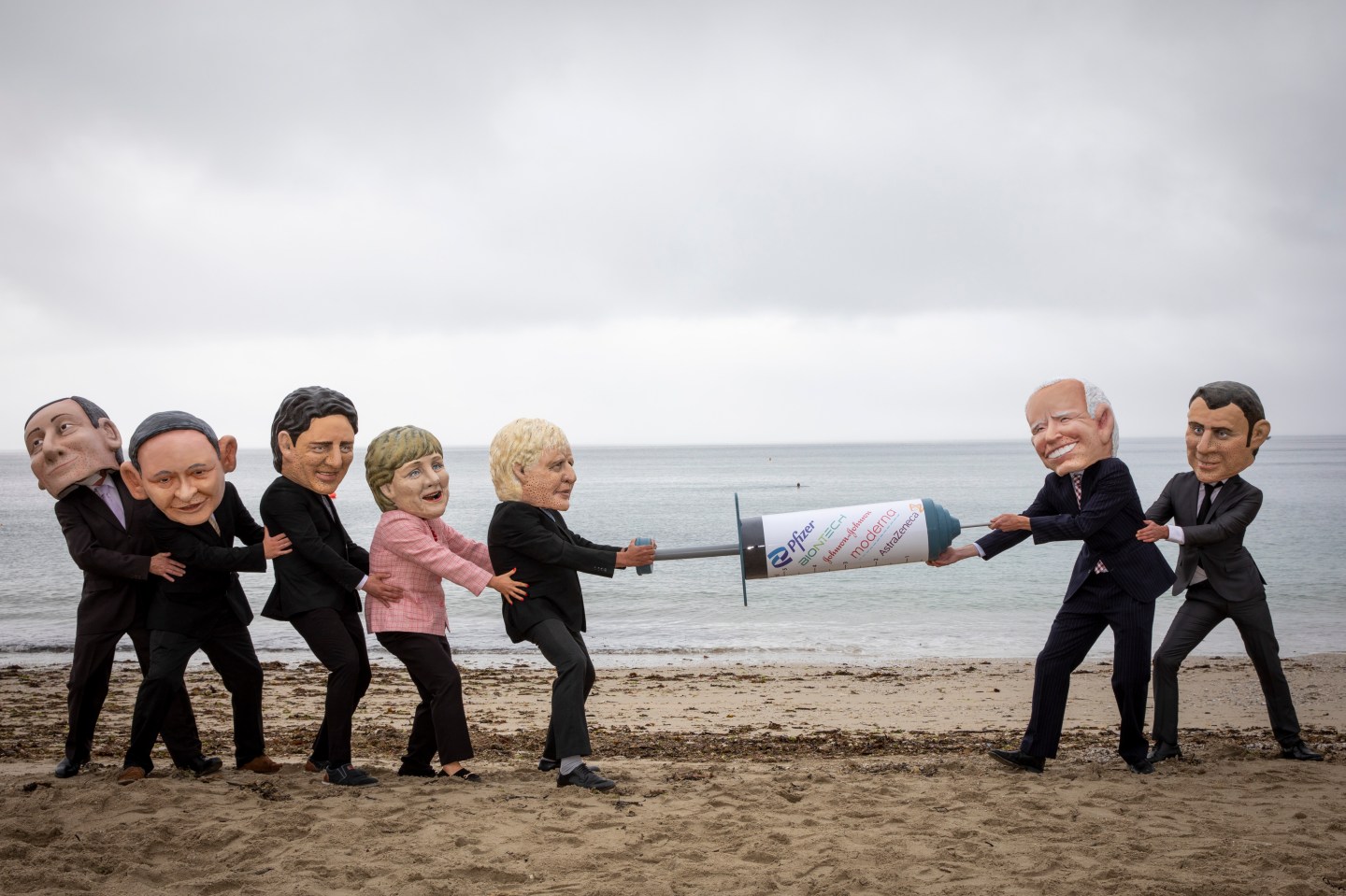 Joe Biden and Emmanuel Macron face off against Boris Johnson and the other G7 leaders in a tussle over a giant syringe, with campaigners for The Peoples Vaccine Alliance pose as G7 leaders, fighting over a COVID-19 vaccine on the 11th of June 2021 near Falmouth, Cornwall, United Kingdom. 
