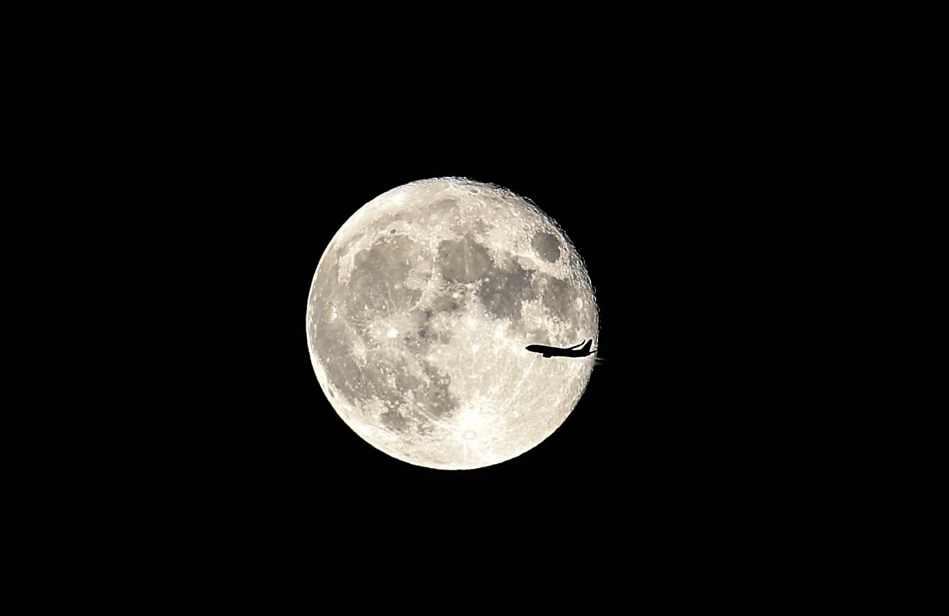 Full moon rises over the sky as a passenger plane flying at the evening hours in Ankara, Turkey on June 25, 2021.