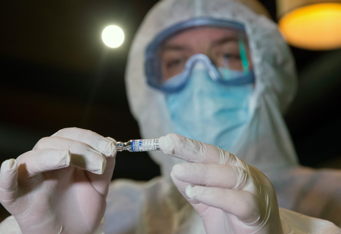 A healthcare worker holds an ampoule with the Gam-COVID-Vac vaccine (under the brand name of Sputnik V) against the novel coronavirus before vaccinating BnB bar chain employees, at the BnB Boys Bar in Simferopol, Crimea.