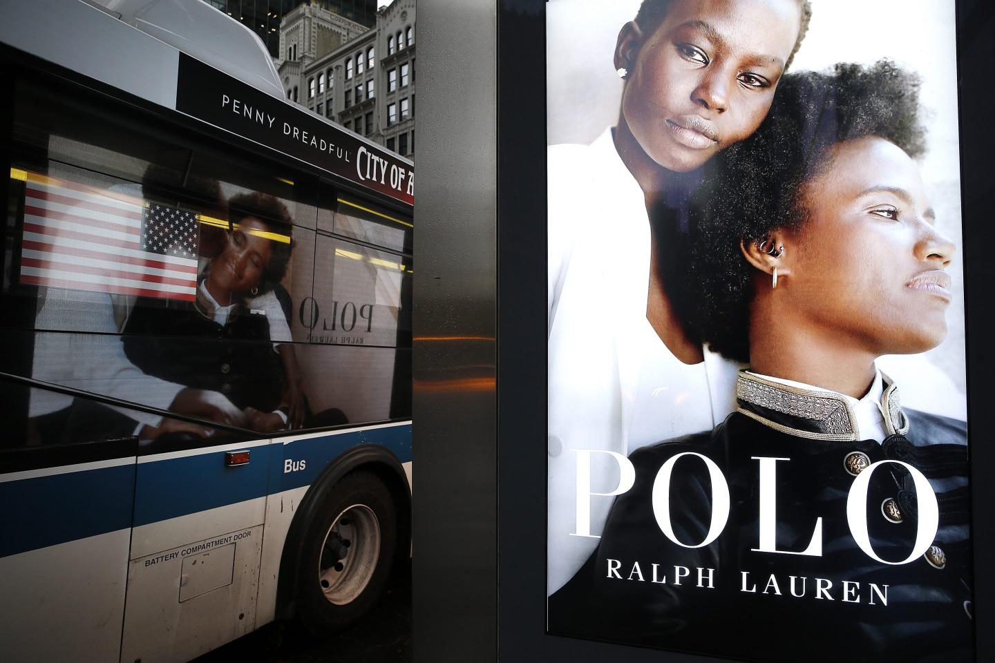 A Polo Ralph Lauren fashion ad is reflected in the window of a city bus in Midtown on November 12, 2020 in New York City.