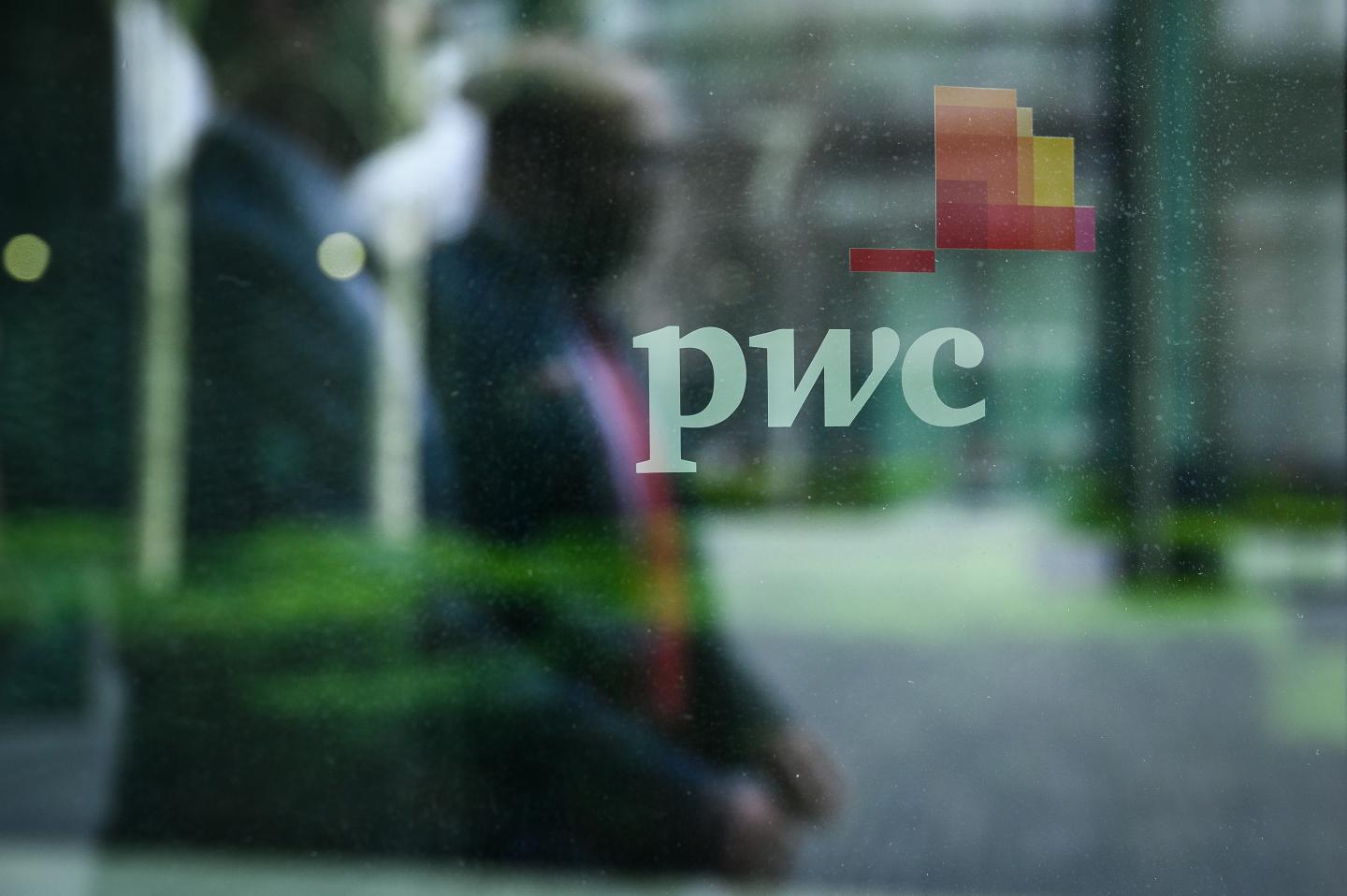 People walk past a sign on a window on the exterior of the PWC London offices on March 31, 2021 in London, England.