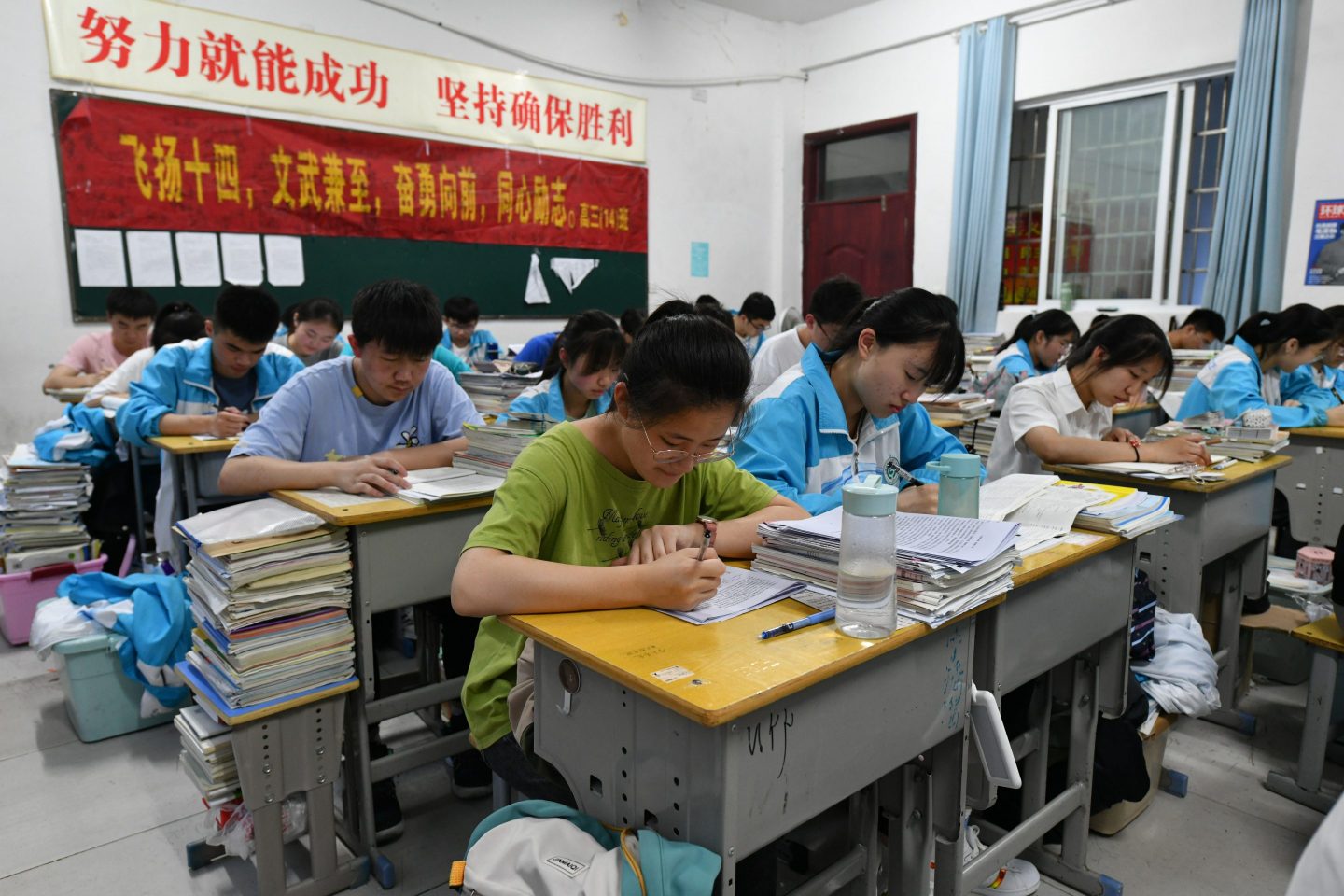 Students are seen revising in a school classroom.In the