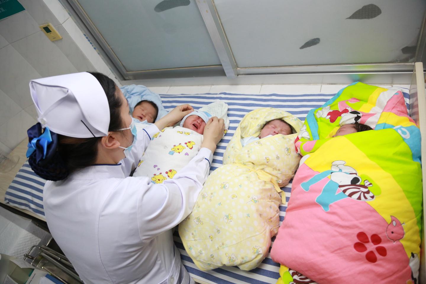A nurse takes care of newborn babies at a hospital on February 12, 2021 in Xiangyang, Hubei Province of China. 