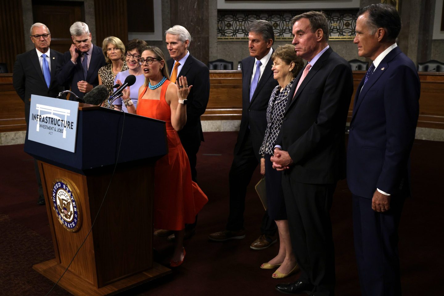 Sen. Kyrsten Sinema (D-AZ) speaks as other supporters of the bipartisan infrastructure bill look on. "Political differences have not been insurmountable – just complex to unravel," writes Jeffrey Sonnenfeld.
