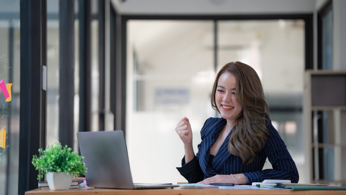 Woman wearing a suit looks at her laptop