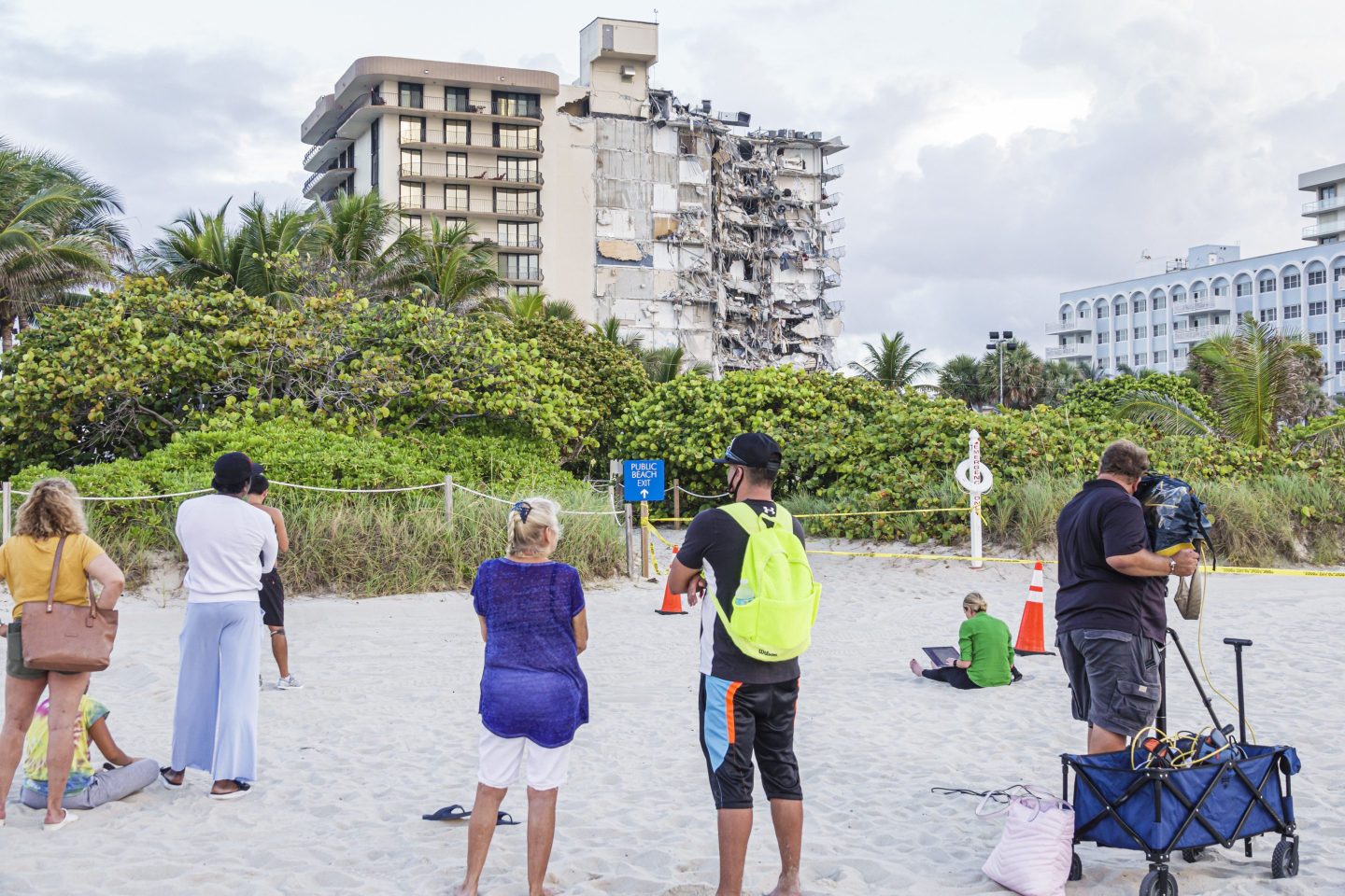 Residents look at the collapsed Champlain Towers building in Surfside, Fla.