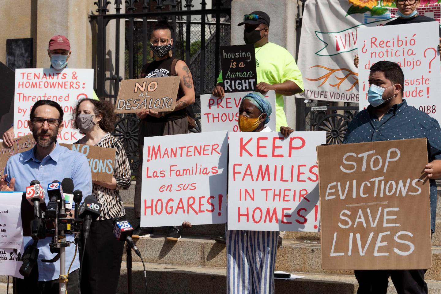 People from a coalition of housing justice groups hold signs protesting evictions during a news conference outside the Statehouse on July 30, 2021 in Boston.