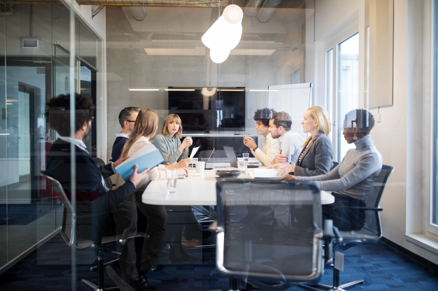Group of businessmen and businesswomen having board meeting in office. Multi-ethnic group of people having meeting in conference room.
