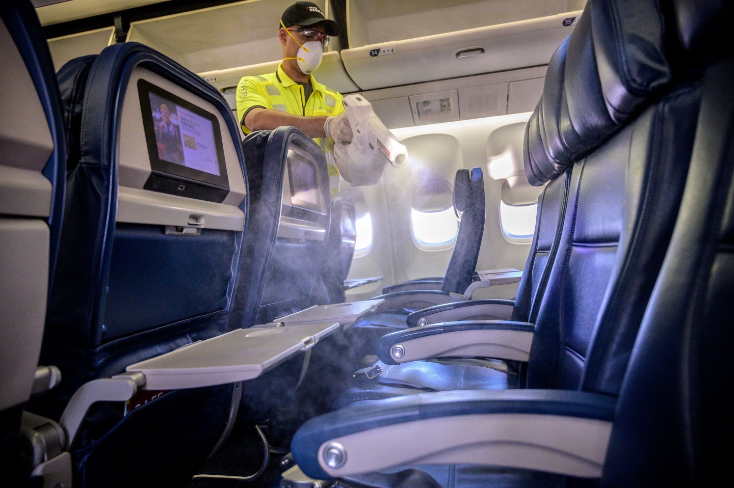 Members of Delta&#8217;s line maintenance crew disinfect the surfaces of the cabin including tray tables, seat backs and in-flight entertainment screens in a Boeing 757 in Atlanta, Ga., on Friday, March 6, 2020. The sanitizing solution is the same solution used to sanitize hospitals nationwide.