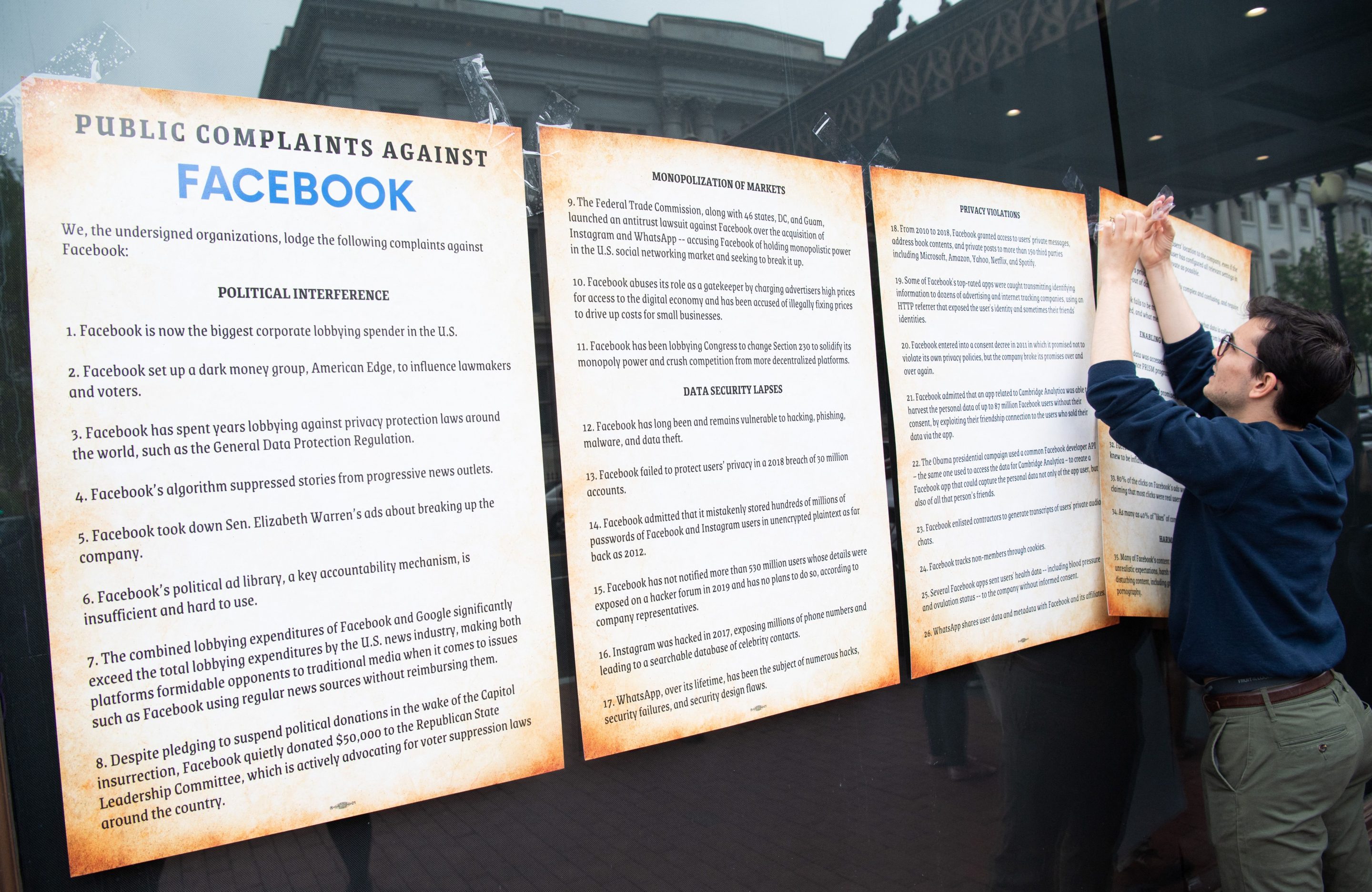 A protester posts a list of “public complaints” against Facebook at a rally in Washington, D.C., in May 2021. “The path from corporate power to regulatory backlash is neither linear nor predominantly about economics,” the authors write. “What’s overlooked in today’s debate is the catalyzing power of popular outrage.”