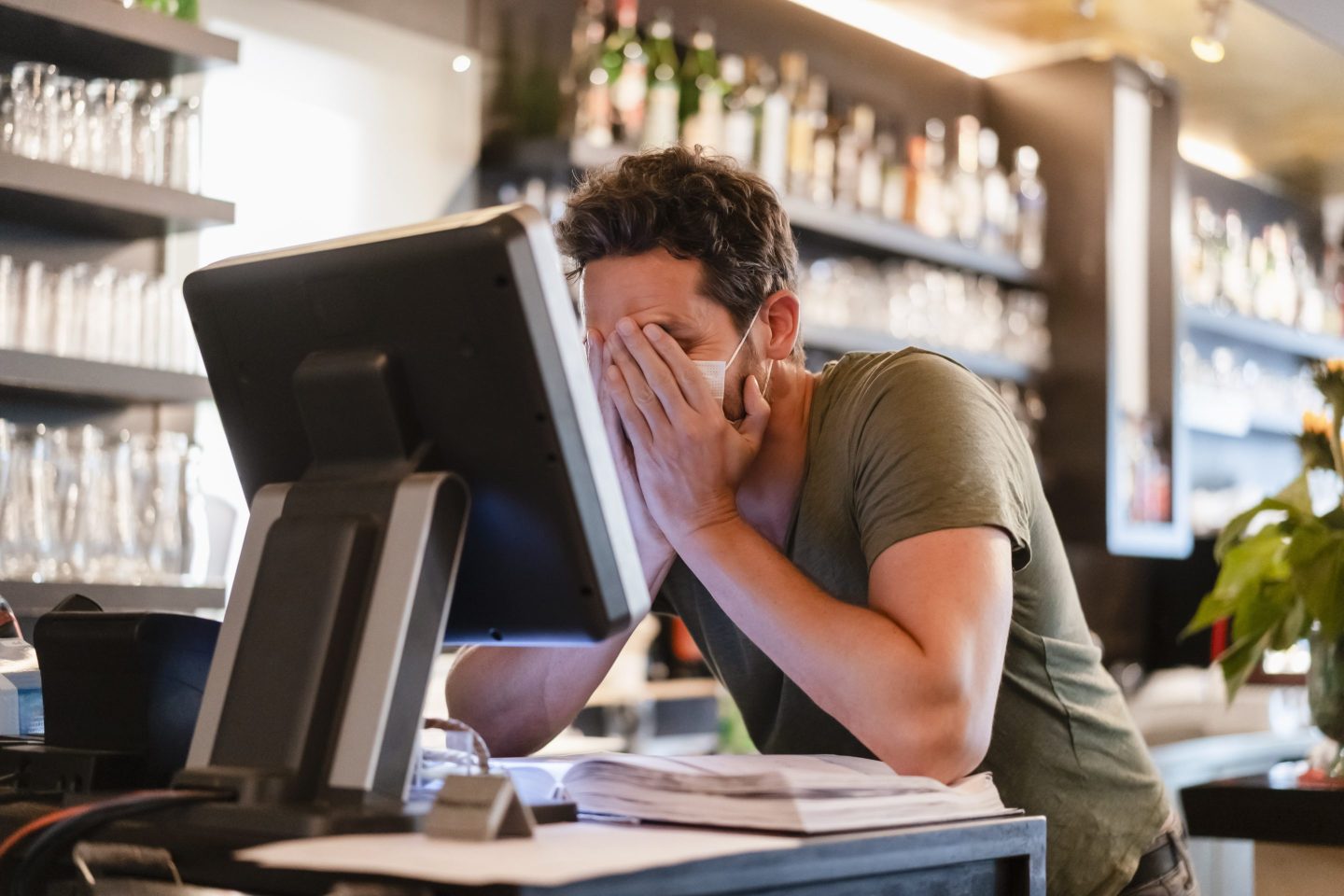 man sitting in front of computer with mask