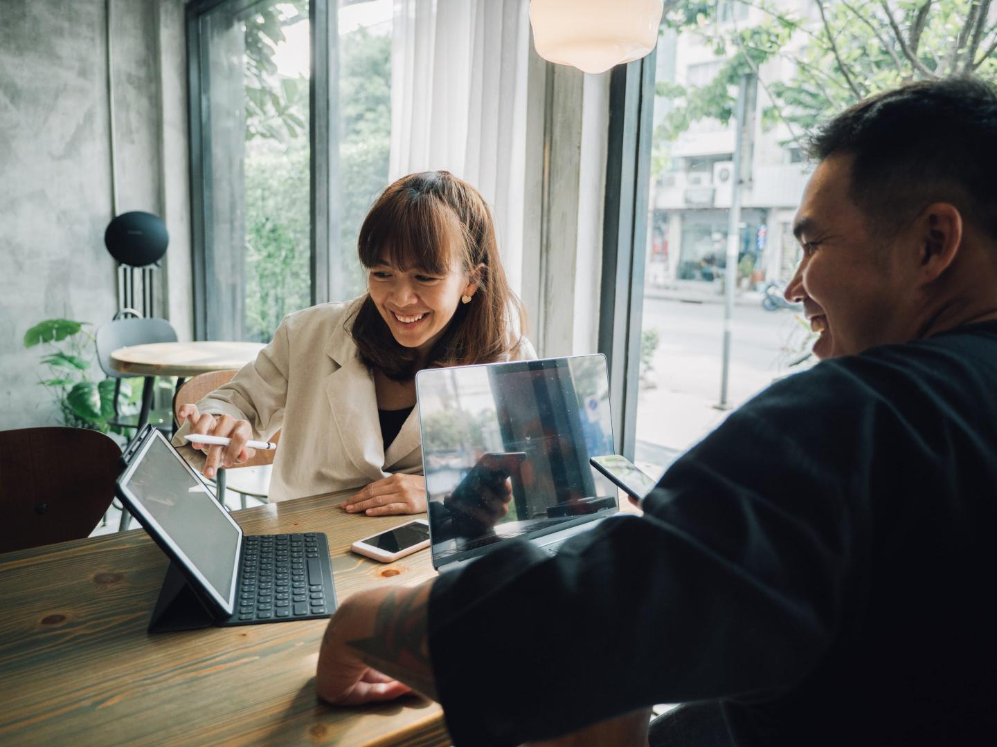 couple shares computer screen at coffee shop