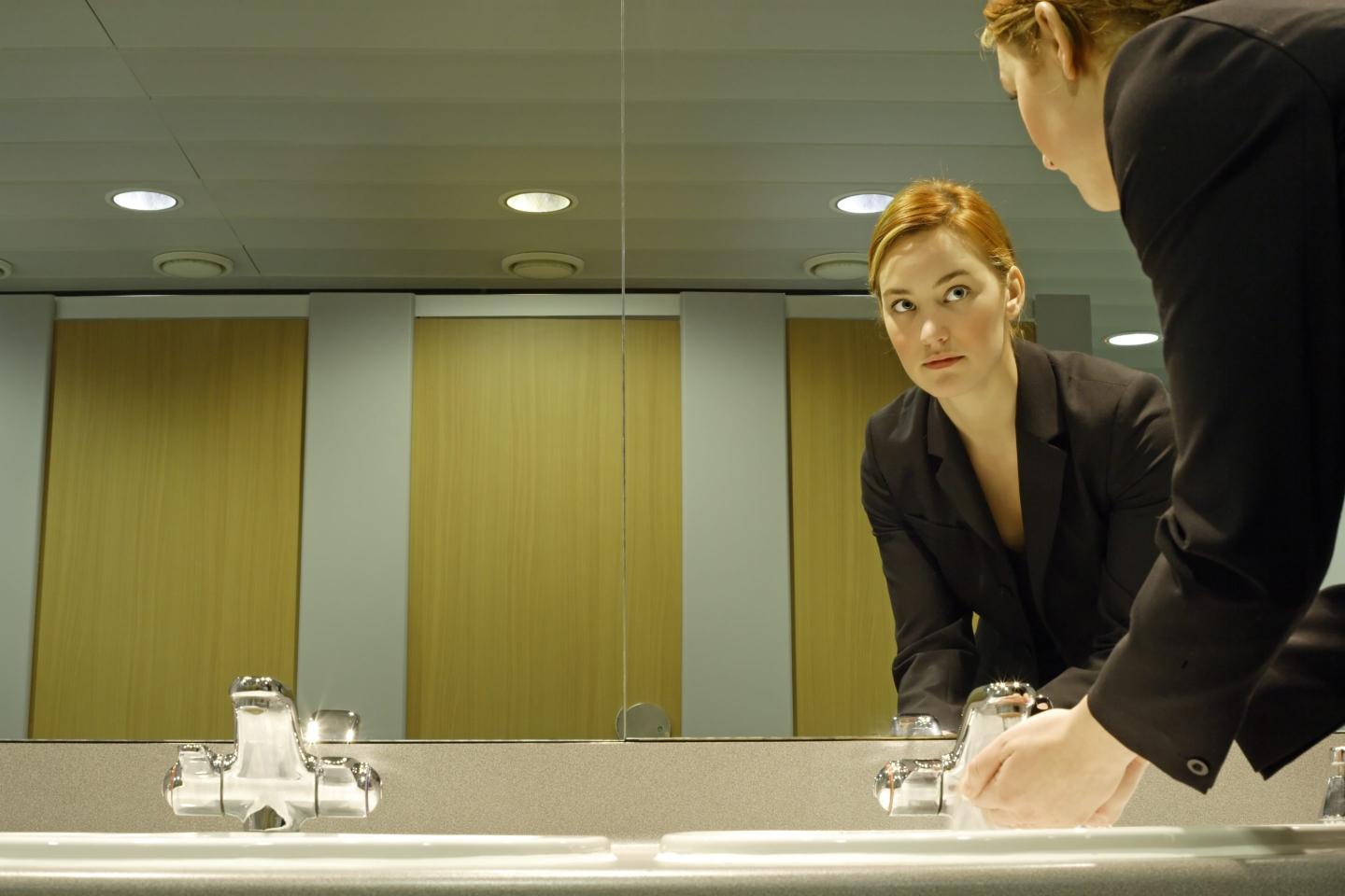 Young businesswoman in bathroom, washing hands