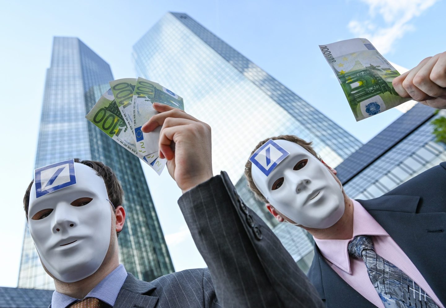 photo of masked protestors outside Deutsche Bank headquarters.