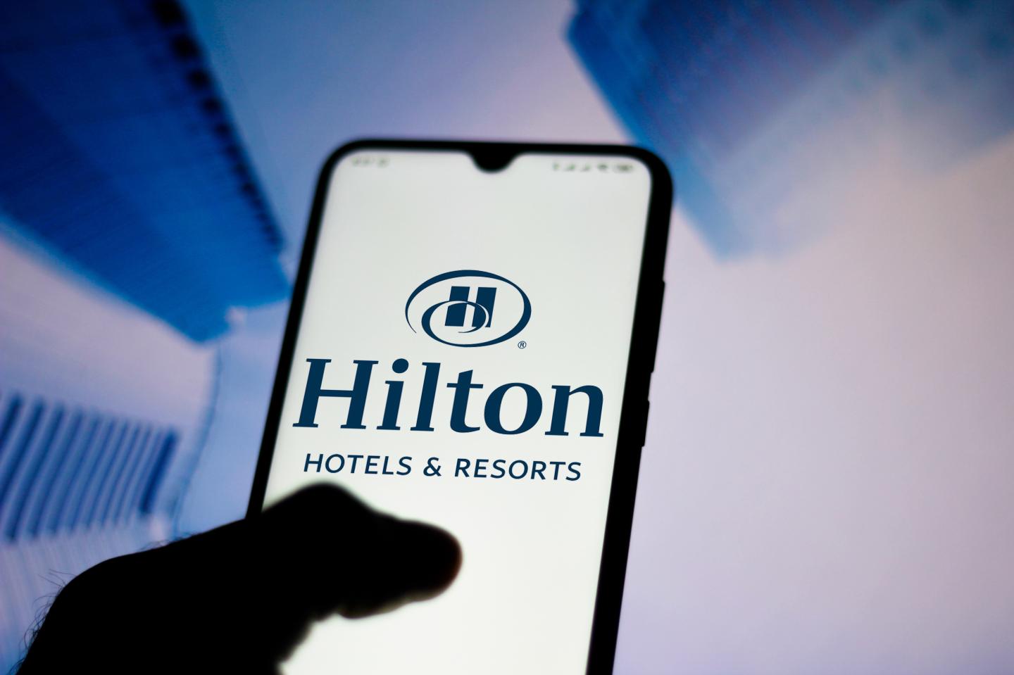 In this photo illustration a Hilton Hotels and Resorts logo seen displayed on a smartphone.