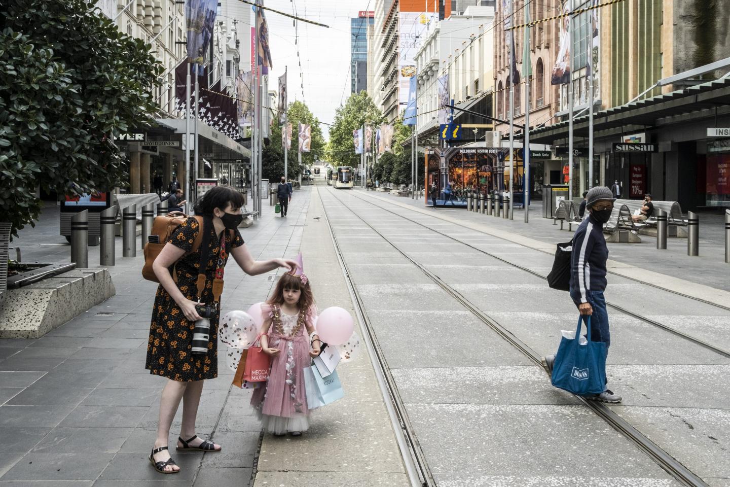 Mother wearing a face mask celebrates her daughter's