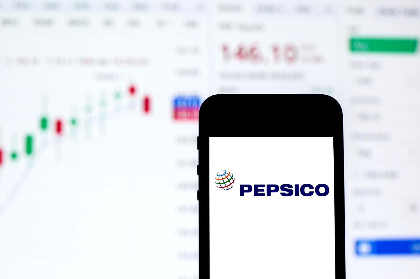 In this photo illustration a PepsiCo logo seen displayed on a smartphone with the stock market information of PepsiCo in the background.