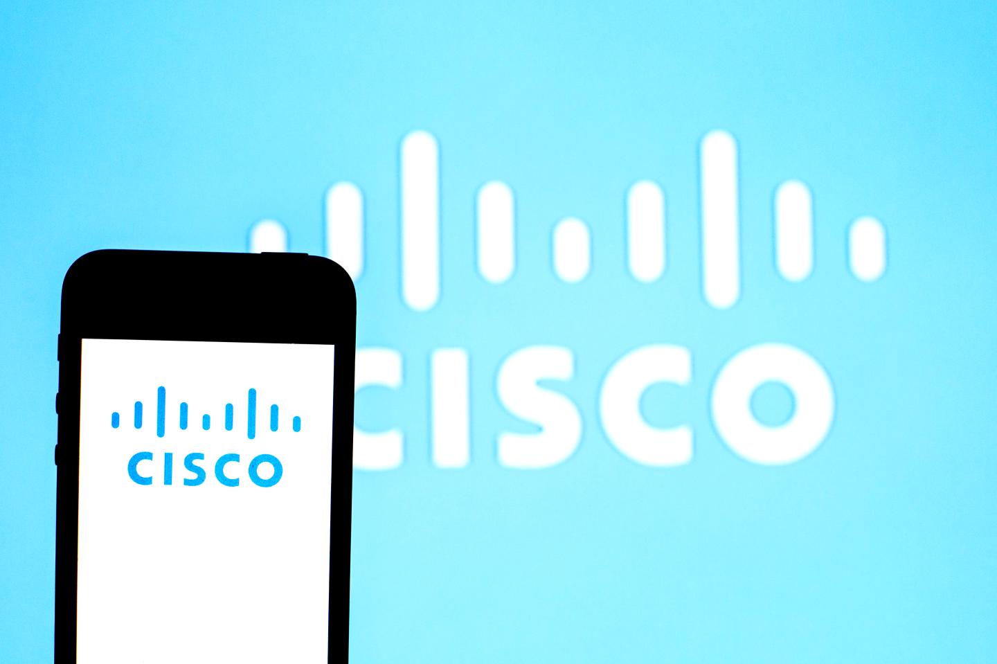 In this photo illustration a Cisco Systems logo seen displayed on a smartphone with a Cisco Systems logo in the background.