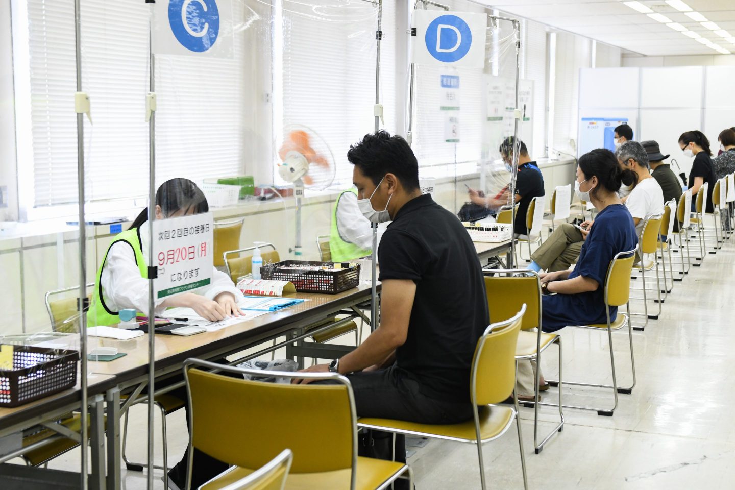 Residents get a consultation after receiving the Moderna Inc. Covid-19 vaccine at a mass vaccination site in Saitama City, Saitama, Japan, on Monday, Aug. 23, 2021. Japan&#8217;s Prime Minister Yoshihide Suga said last week that he expects 60% of the population to be fully vaccinated by the end of next month and plans to distribute enough doses to inoculate 80% of eligible people by early October. Photographer: Noriko Hayashi/Bloomberg via Getty Images