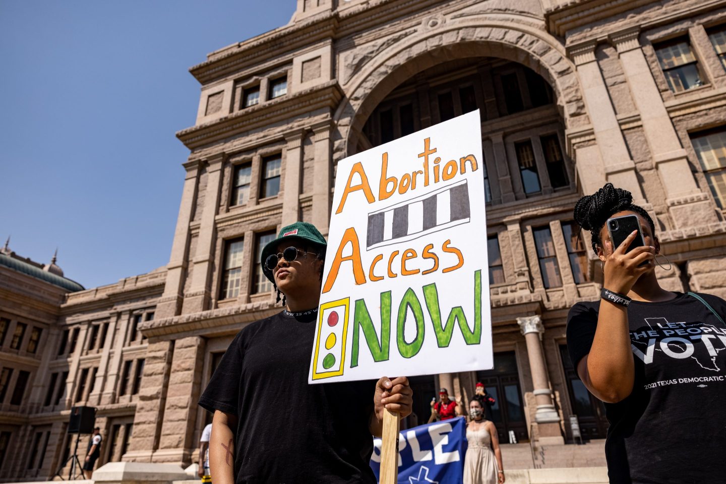 A woman carrying a sign protesting Texas abortion ban