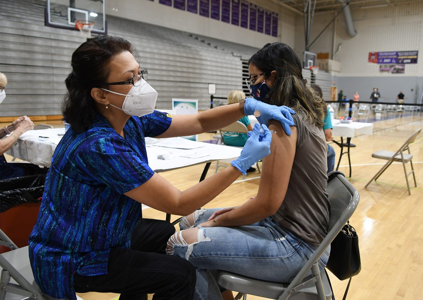 A nurse administers a dose of a COVID-19 vaccine in Winter Springs, Fla. Resistance to vaccine mandates by political leaders in some states, the authors write, is "an unplanned and deplorable experiment, which has turned vast populations into human subjects."