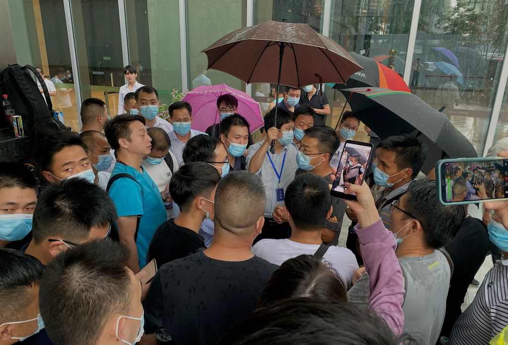 People gather outside the Evergrande headquarters in Shenzhen, southeastern China on September 14, 2021, as the Chinese property giant said it is facing &#8220;unprecedented difficulties&#8221; but denied rumours that it is about to go under.