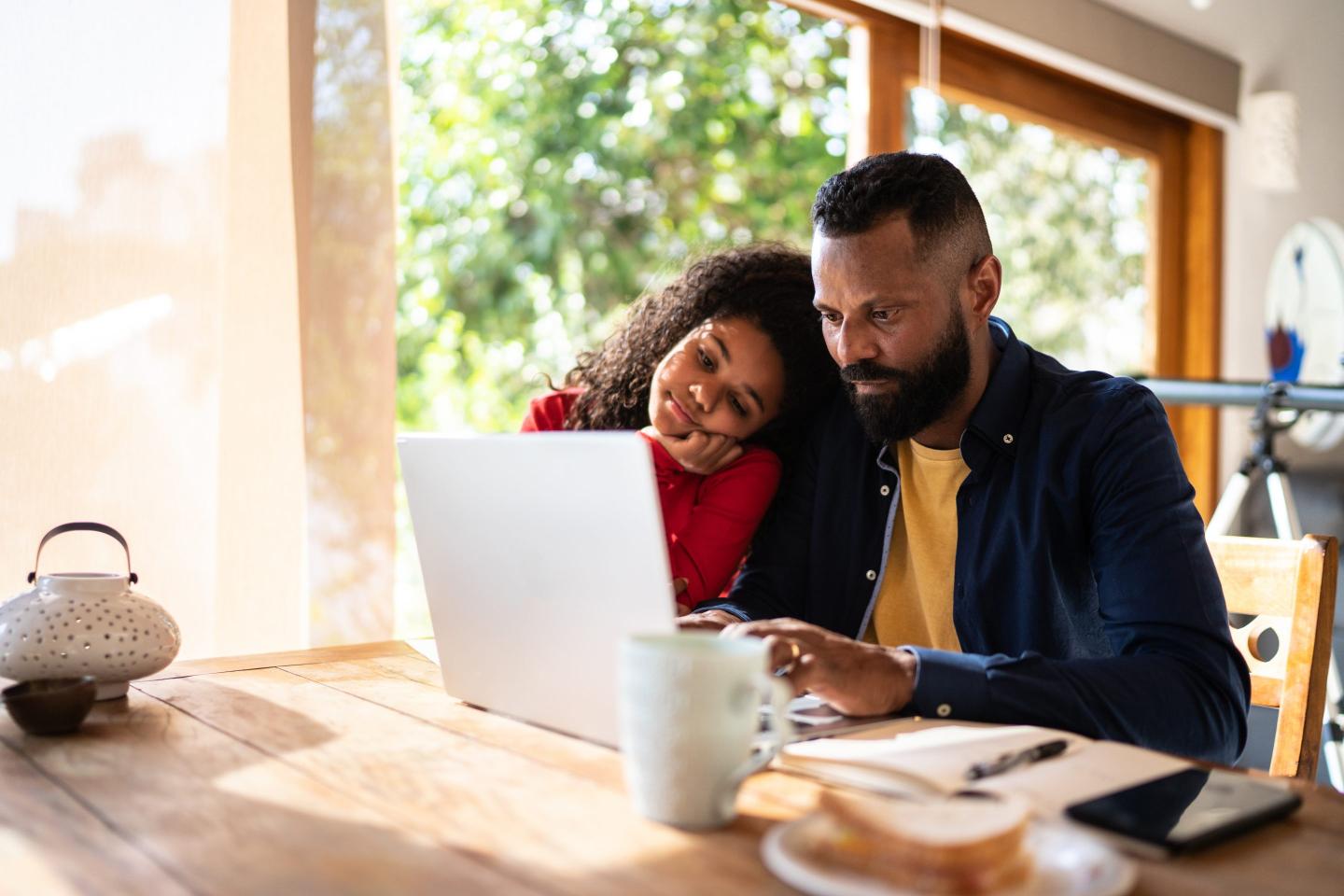 Man working at home with daughter
