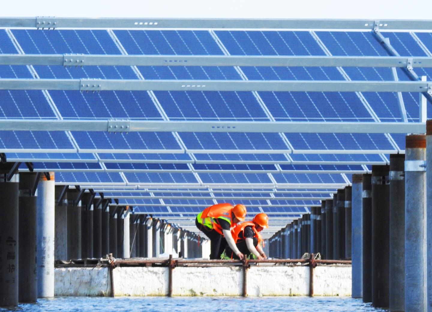 Workers install solar panels at a fishery-solar hybrid power station on September 14, 2021 in Lianyungang, Jiangsu Province of China.