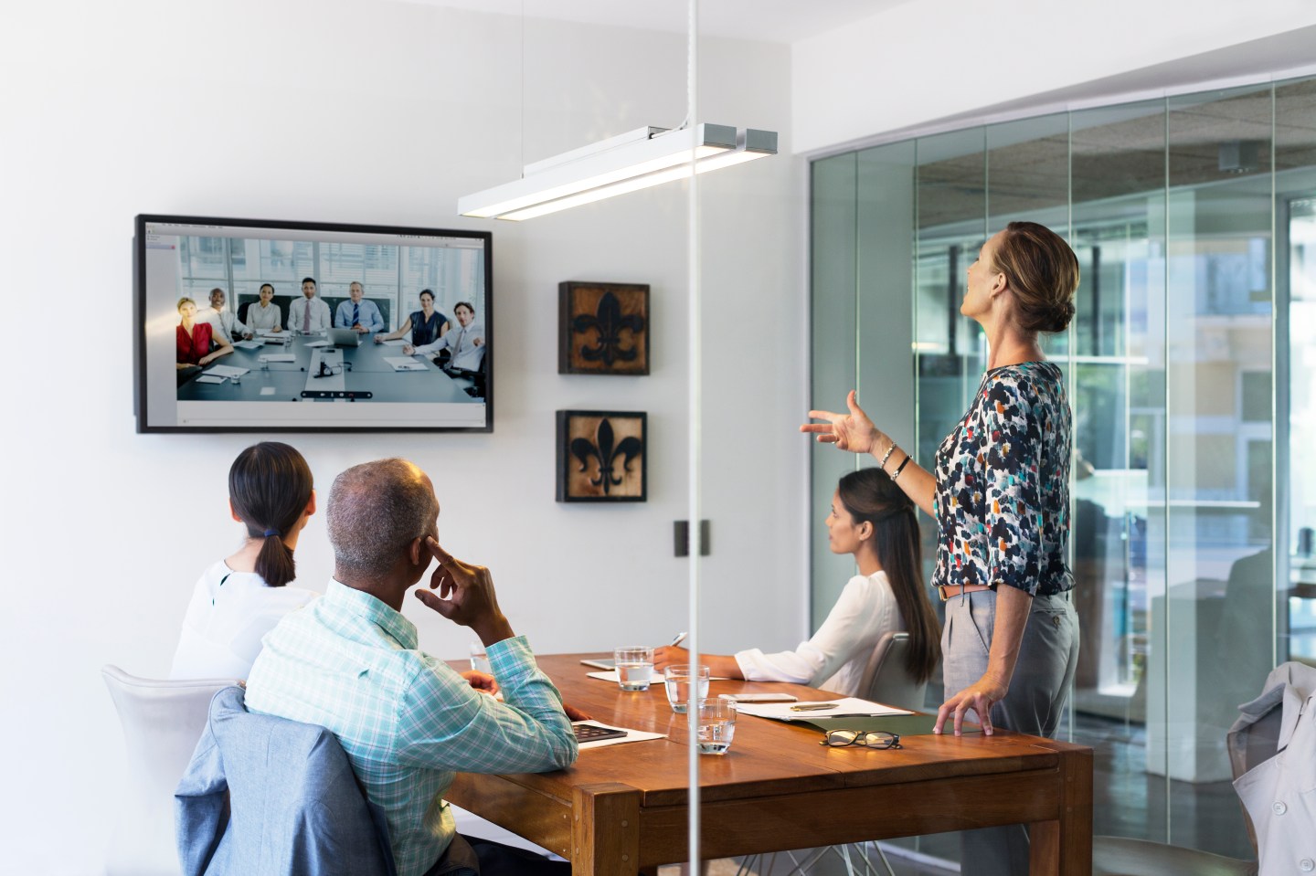 Multi-ethnic business people video conferencing at desk in board room