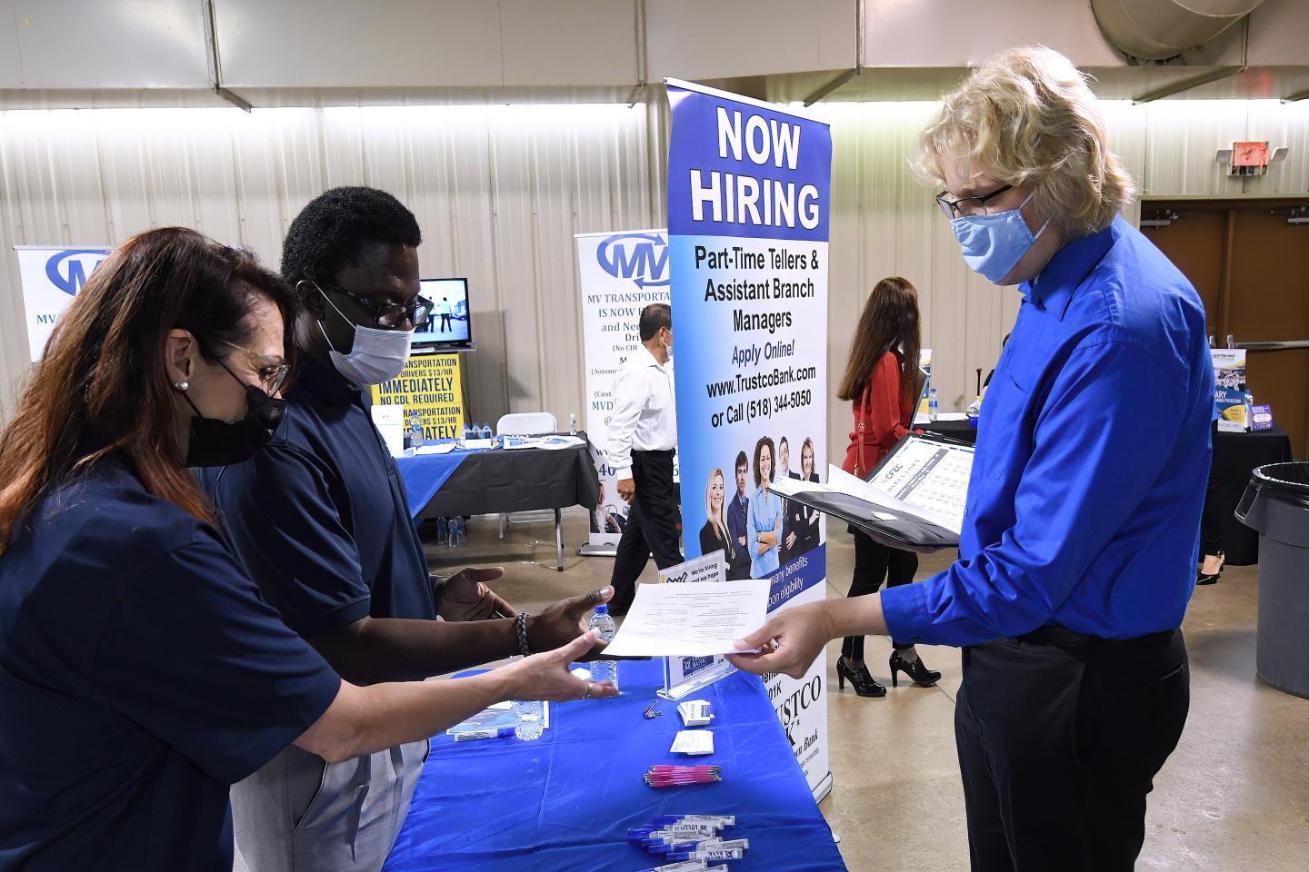 A man hands his resume to an employer at the 25th annual Central Florida Employment Council Job Fair at the Central Florida Fairgrounds.