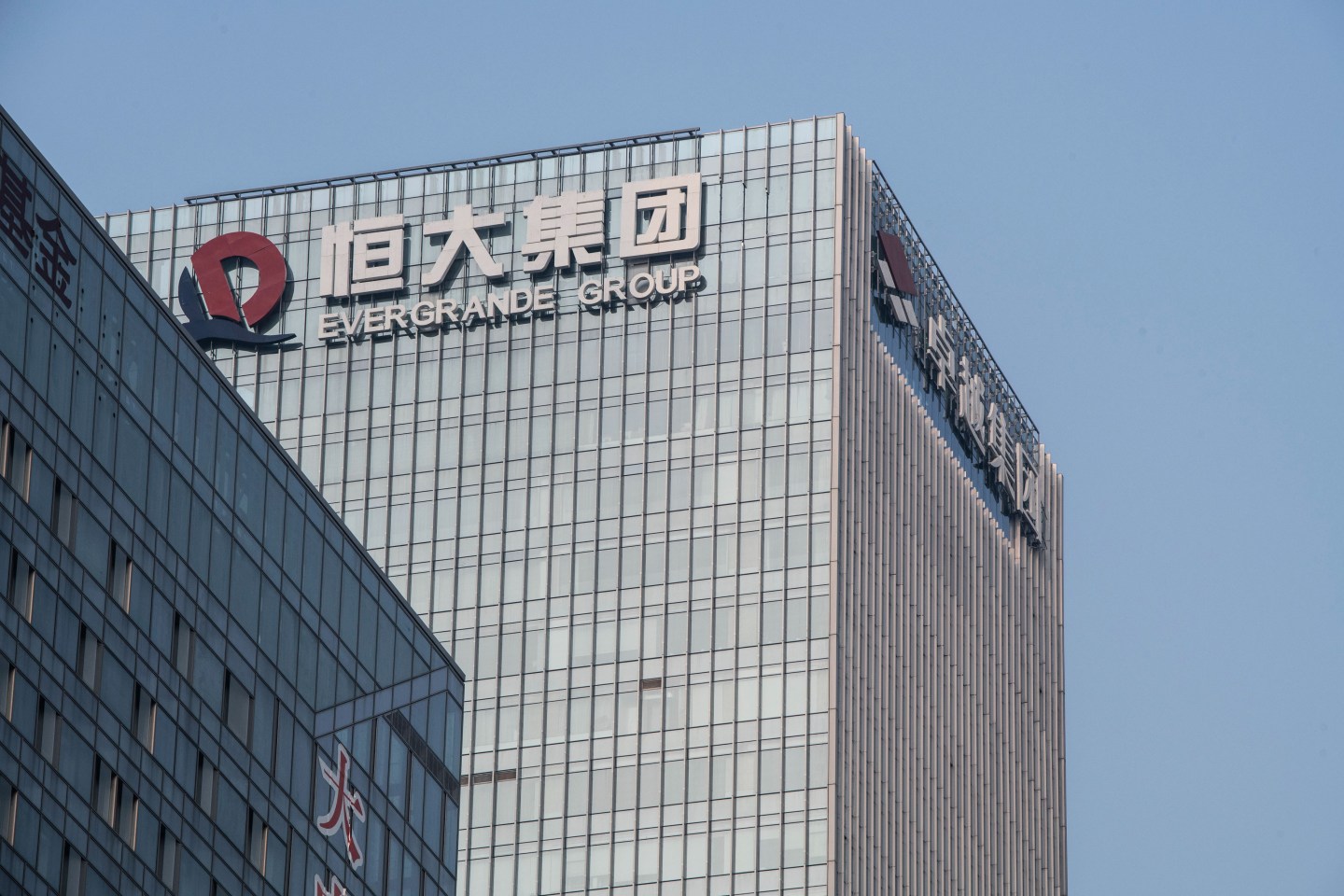 The China Evergrande Group logo displayed atop the company&#8217;s headquarters in Shenzhen, China, on Thursday, Sept. 30, 2021. China Evergrande Group started returning a small portion of the money owed to buyers of its investment products, weeks after people protested against missed payments. Photographer: Gilles Sabrie/Bloomberg via Getty Images